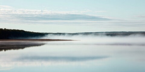 Mist rising over calm lake water mirroring a dark forest under a clear sky, capturing a serene nature scene