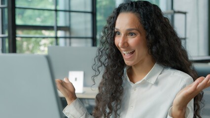 Pensive thinking Hispanic business woman talking video call with computer in modern office...