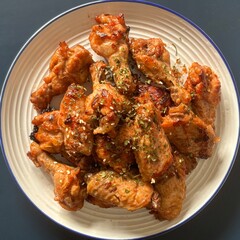 Spicy honey wings on white plate and blue background