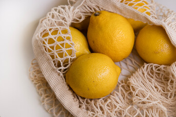 Fresh Lemons in Mesh Bag – Modern Lifestyle Concept on White Minimal Background