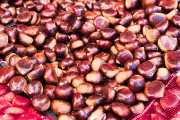Pile of fresh autumn chestnuts at market stall
