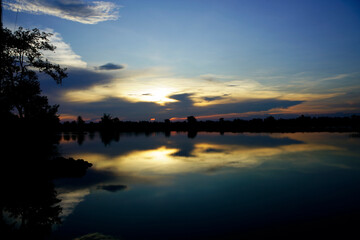 Serene Sunset Over Calm Water with Reflection and Colorful Sky