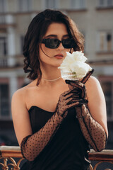 Intense gaze of woman in black with fishnet gloves