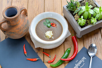 Mushroom cream soup in a white plate on a wooden table with decor