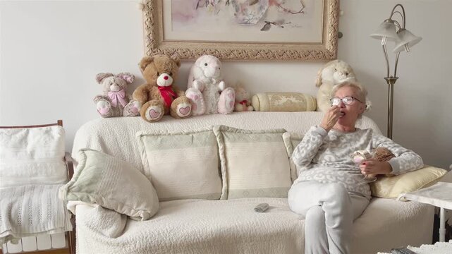 Beautiful elderly woman watching TV with ice cream