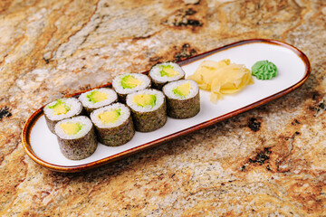 Fresh sushi rolls served with ginger and wasabi on a marble table