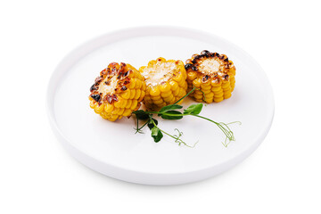 Grilled corn on white plate with fresh herbs showing summer flavors