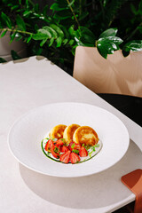 Delicious dish with cottage cheese pancakes and fresh strawberries on a modern table