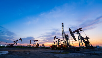 in the evening, oil pumps are running, The oil pump and the beautiful sunset reflected in the...
