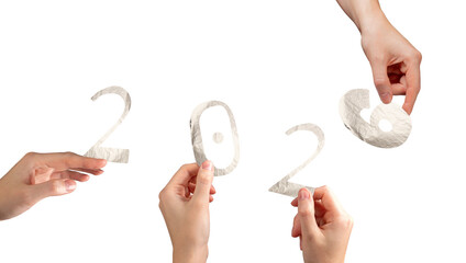 Hand holding silver metallic 2026 number in festive winter theme. Green and shiny foil typography