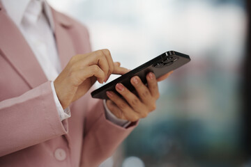 Close-up of a businesswoman using a smartphone, representing communication, technology, work, and modern lifestyle.