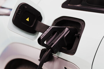 Electric car charging at a station, symbolizing clean energy, modern transportation, and sustainable technology.