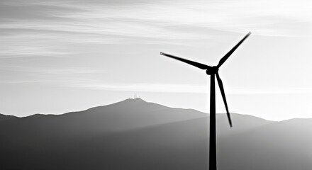 Obraz premium Renewable Energy Wind Turbine Against Foggy Mountain Monochrome