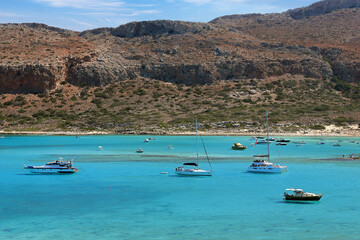 Boats and tourists on the Greek Balos Lagoon on a sunny day, Crete