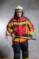 Feuerwehr Mann mit Feuerwehraxt in Einsatz Uniform. Studioaufnahme zeigt sympathischen Feuerwehr Mann.