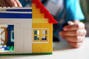 Naklejka premium Junge baut mit Bausteinen ein Haus