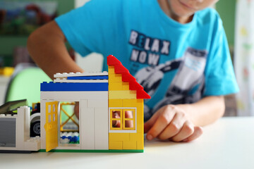 Naklejka premium Junge baut mit Bausteinen ein Haus