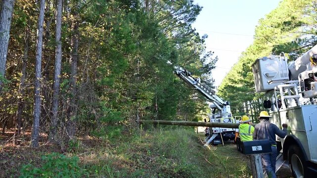 Men Installing a new electric power pole in a rural area