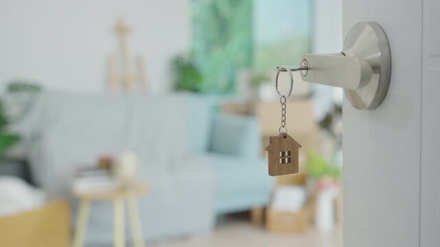 Moving house, relocation. The key was inserted into the door of the new house, inside the room was a cardboard box containing personal belongings and furniture. move in the apartment or condominium