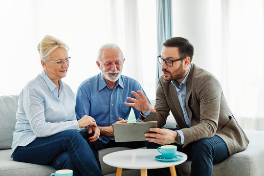 Senior couple having a meeting with an agent, businessman, salesperson or doctor in his office