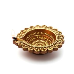 Lit Diya lamp with ornate gold accents on white background