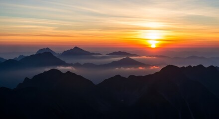 Obraz premium Sunrise over mountain peaks a scenic landscape with fog creating a tranquil atmosphere
