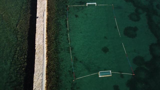 water polo field by the sea, by the concrete jetty, sunny day, summer, calm sea, view from a drone