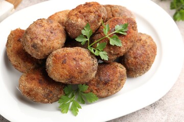 Tasty meat patties with parsley on grey table, closeup
