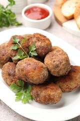 Tasty meat patties served on grey table, closeup