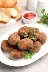 Tasty meat patties served on grey table, closeup