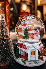 A Christmas souvenir crystal ball with a funny snowman inside, New Year's gifts and shopping at the holiday fair