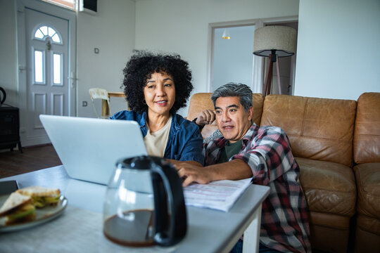 Middle aged couple managing finances at home - Powered by Adobe