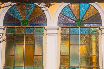 Dettaglio di una finestra in stile liberty composta da vetri cattedrale colorati in un villino storico del Lido di Venezia