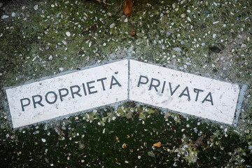 La scritta propriet&agrave; privata sul pavimento del cortile di un ristorante abbandonato