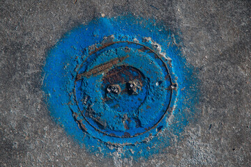 Dettaglio di un chiusino idraulico dipin to di blu