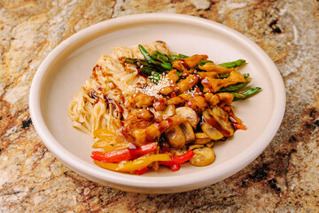 Delicious Asian stir-fry served with noodles on a granite countertop
