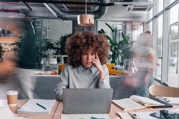 Stressed businesswoman feeling overwhelmed by busy office environment