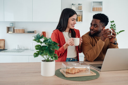 Diverse couple drinking coffee preparing for remote work morning