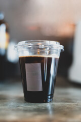 Close up of a plastic cup iced americano with no straw. Concept for reduce plastic pollution and support green eco friendly products.