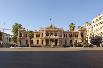 Obraz premium Damascus, Syria 08.08.2025 Historic Hijaz Railway station with Islamic architectural design and the new Syrian revolution flag waving above. Iconic Middle Eastern travel and cultural heritage landmark