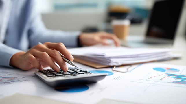Personne utilisant une calculatrice pour analyser des documents financiers
