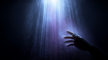 Reaching hand toward illuminated light rays in dark setting with moody lighting.