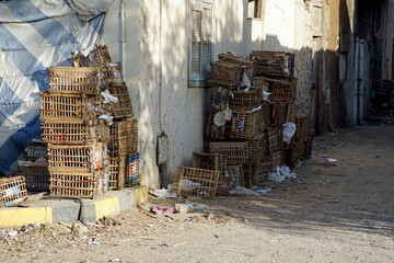 Narrow, dirty dirt road between crumbling multi-story buildings