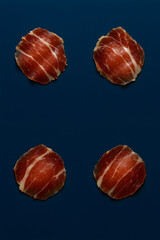 four Jamón Ibérico ham on Blue Background	
