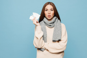 Young woman wear sweater scarf hold in hand paper tissue blowing nose look camera isolated on plain...