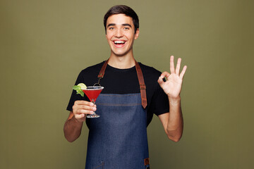 Young man barista bartender barman employee wears jeans apron black t-shirt work in coffee shop...