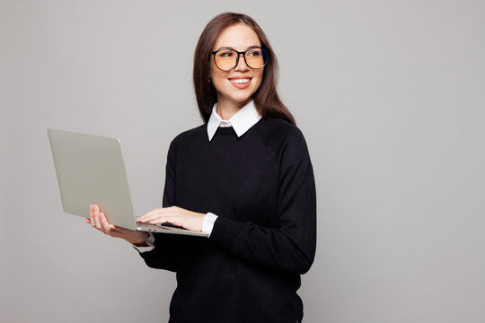 Young successful employee IT business woman corporate lawyer she wear black sweater shirt work in office hold use laptop pc computer look aside on area isolated on plain grey color background studio. - Powered by Adobe