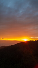 Beautiful sunrise over the mountain with colorful sky and morning mist, peaceful landscape of Thailand nature, mountain sunrise, travel, and adventure concept.