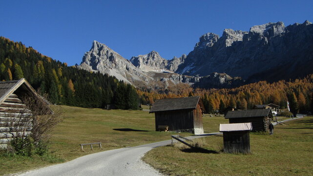 Scenic autumn landscape in Val San Nicol&ograve;, Val di Fassa, Dolomites, Trentino, Italy. Vibrant golden larch trees, colorful mountains and peaceful alpine valley under warm autumn light