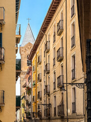 Beautiful street view of Old town in Pamplona featuring balconies, flags, and cobblestone textures